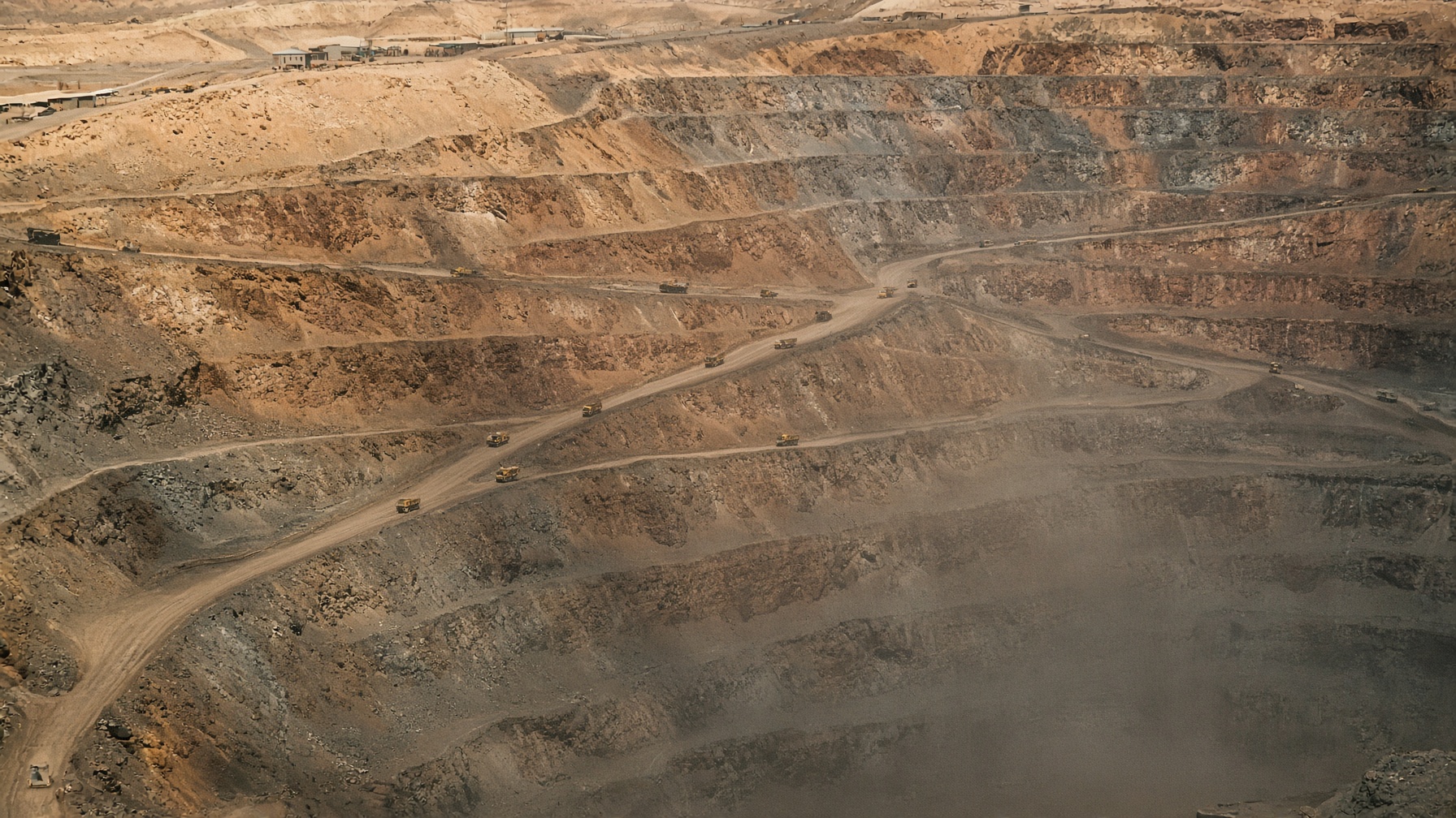 Rajo abierto de cobre en el norte de Chile: terrazas de óxido, polvo y camiones de extracción.